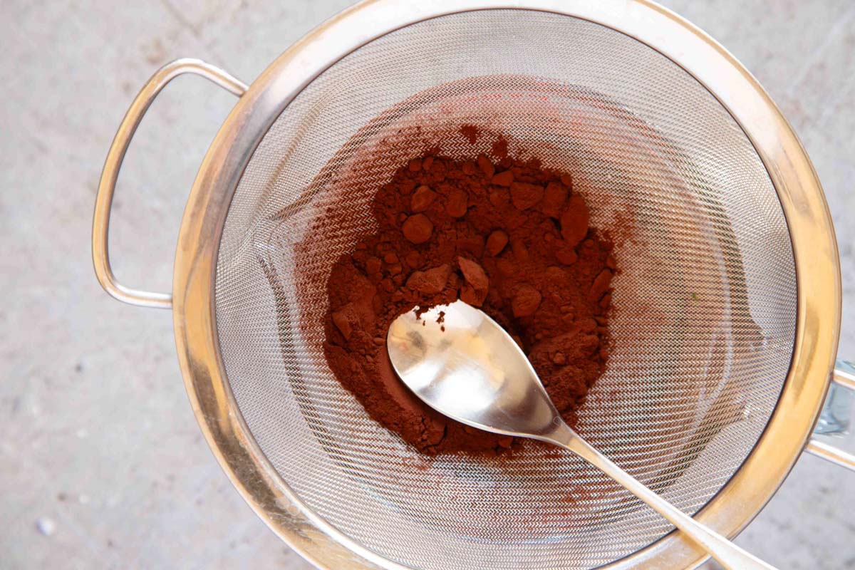 Sifting cocoa into the brownie batter.