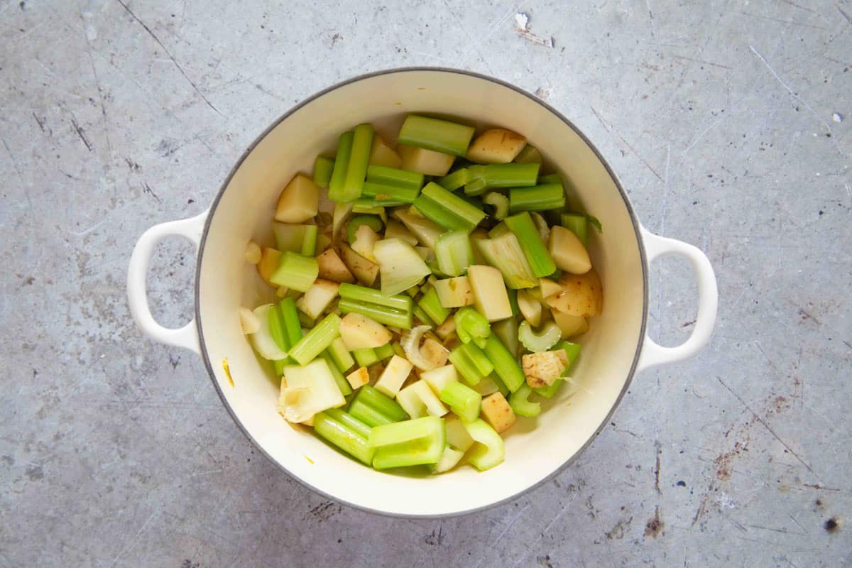 The celery and potato in the soup pan.