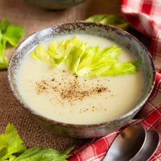 a bowl for freshly made celery soup garnished with celery leaves and celery salt