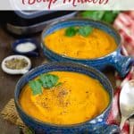 Two blue bowls of golden orange carrot and lentil soup on a table ready to be enjoyed