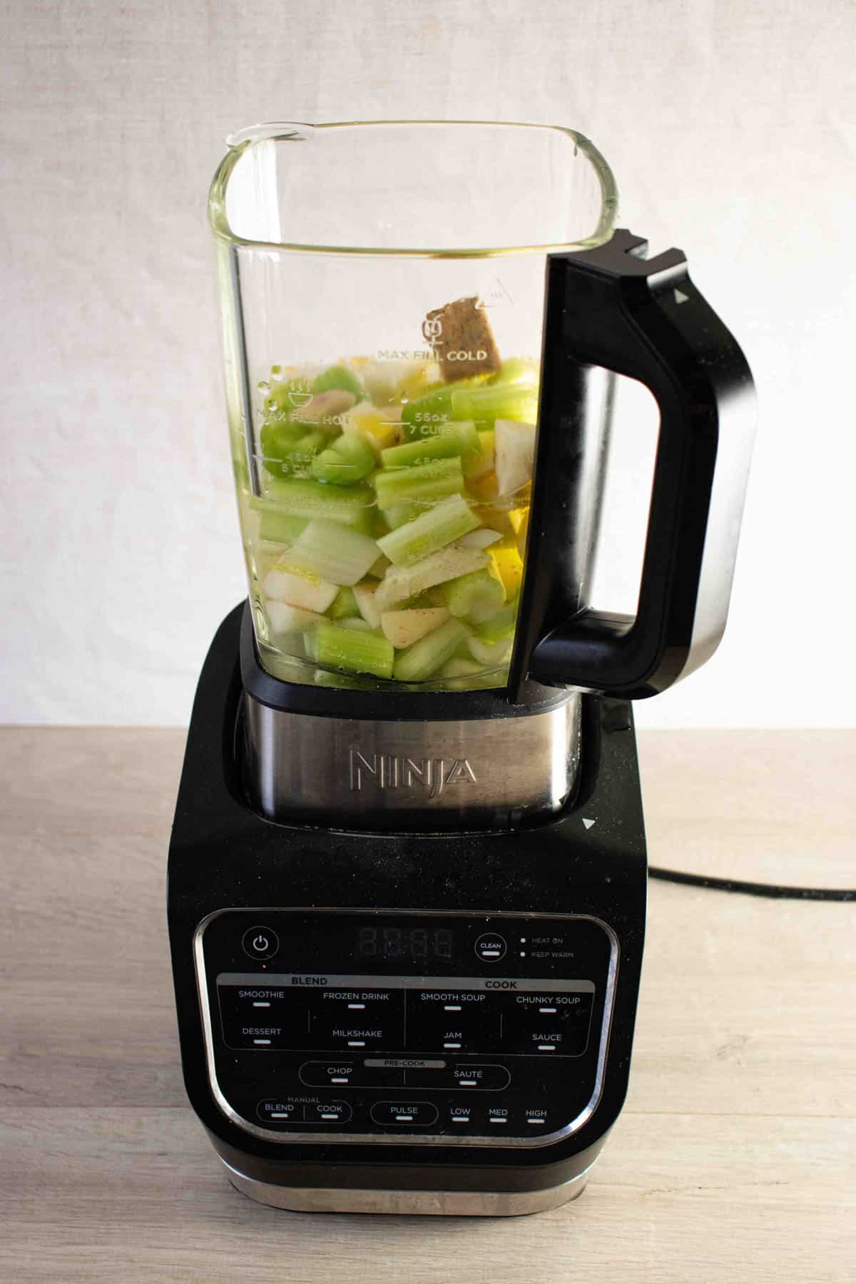 a soup maker filled with the raw ingredients for celery soup
