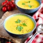 two bowls of pale yellow curried cauliflower soup ready to enjoy