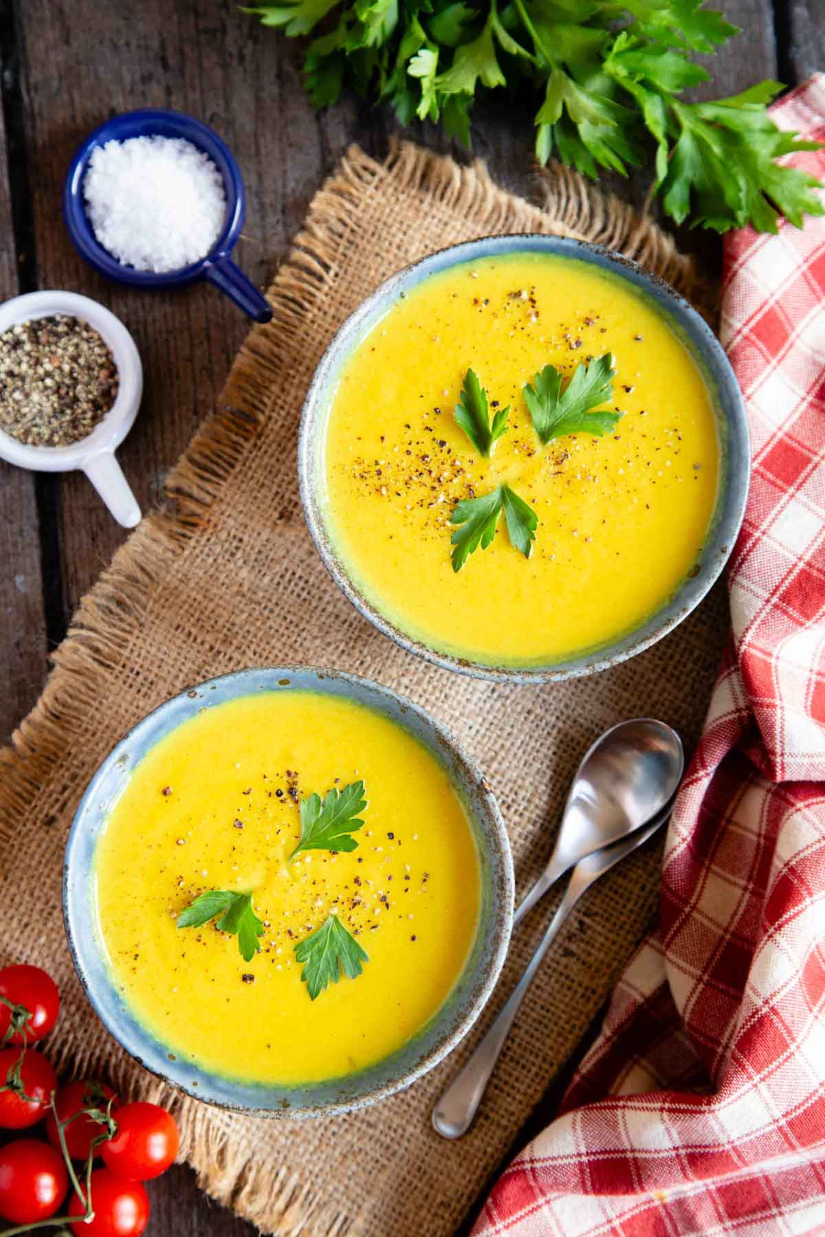 two bowls of pale yellow curried cauliflower soup ready to enjoy