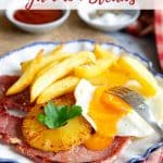 a plate of gammon, egg with runny yolk and chips with a caramelised pineapple ring served and ready to enjoy