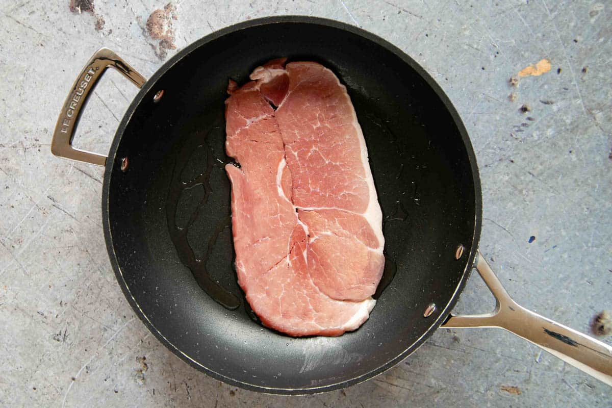 cooking the gammon steak in a large frying pan