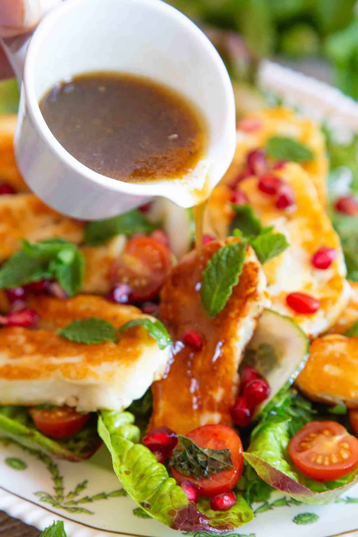 pouring dressing over the salad
