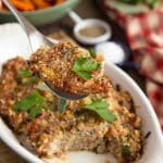 a portion of the cooked stuffing is being lifted from the bowl with a spoon