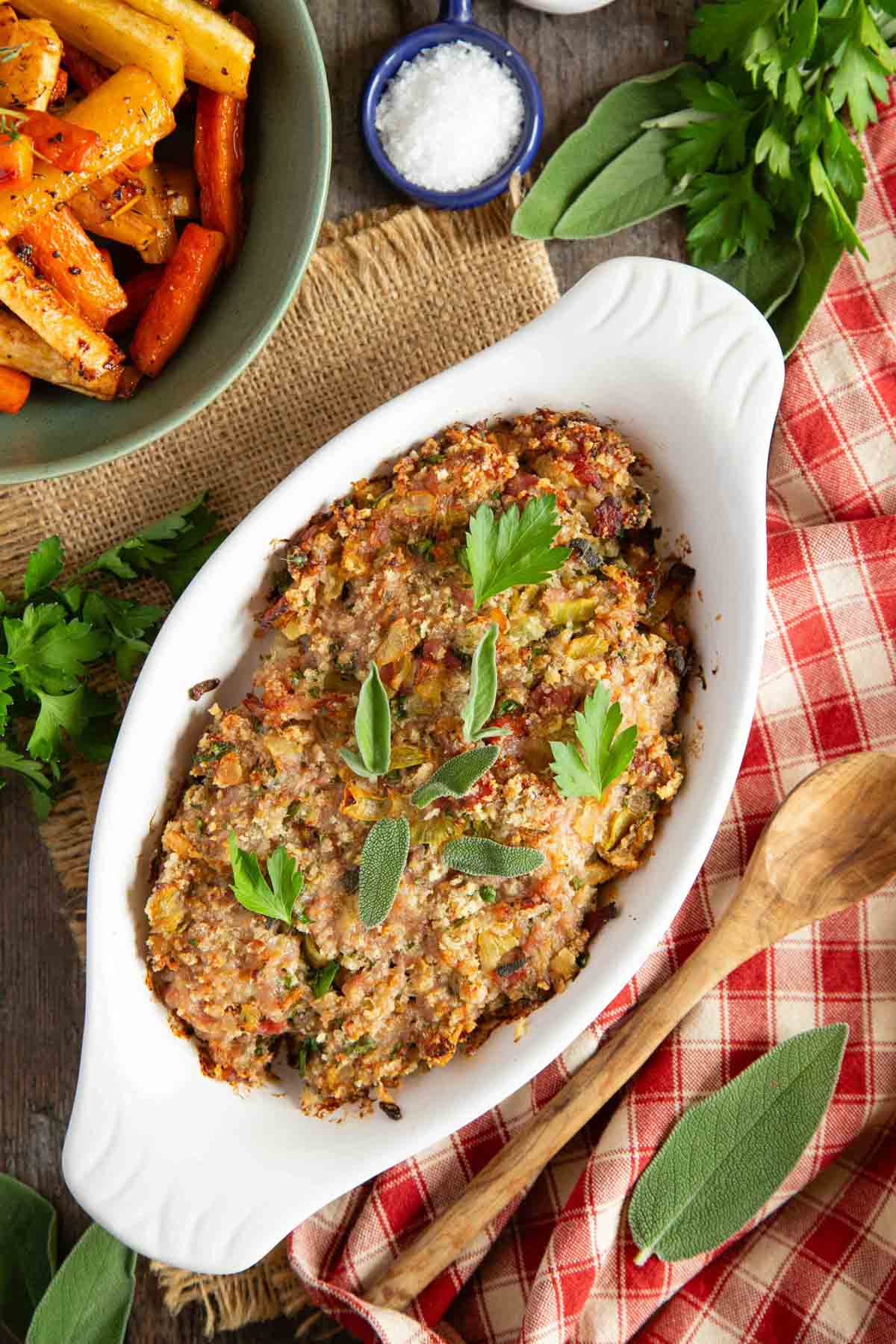 the cooked stuffing is garnished with fresh sage and parsley ready to be served