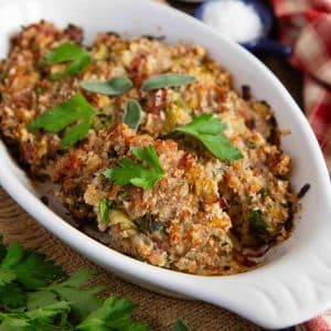 the cooked stuffing is garnished with fresh sage and parsley ready to be served