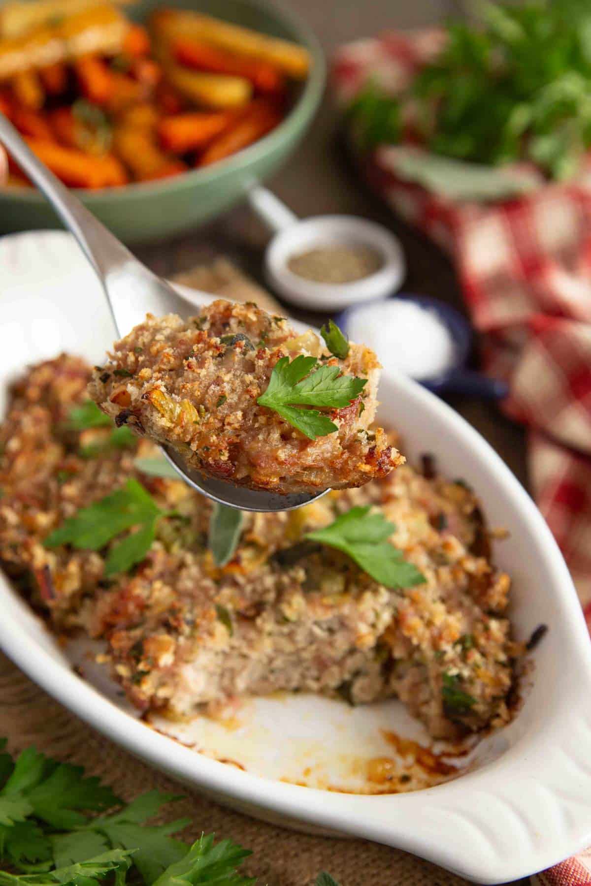 a portion of the cooked stuffing is being lifted from the bowl with a spoon