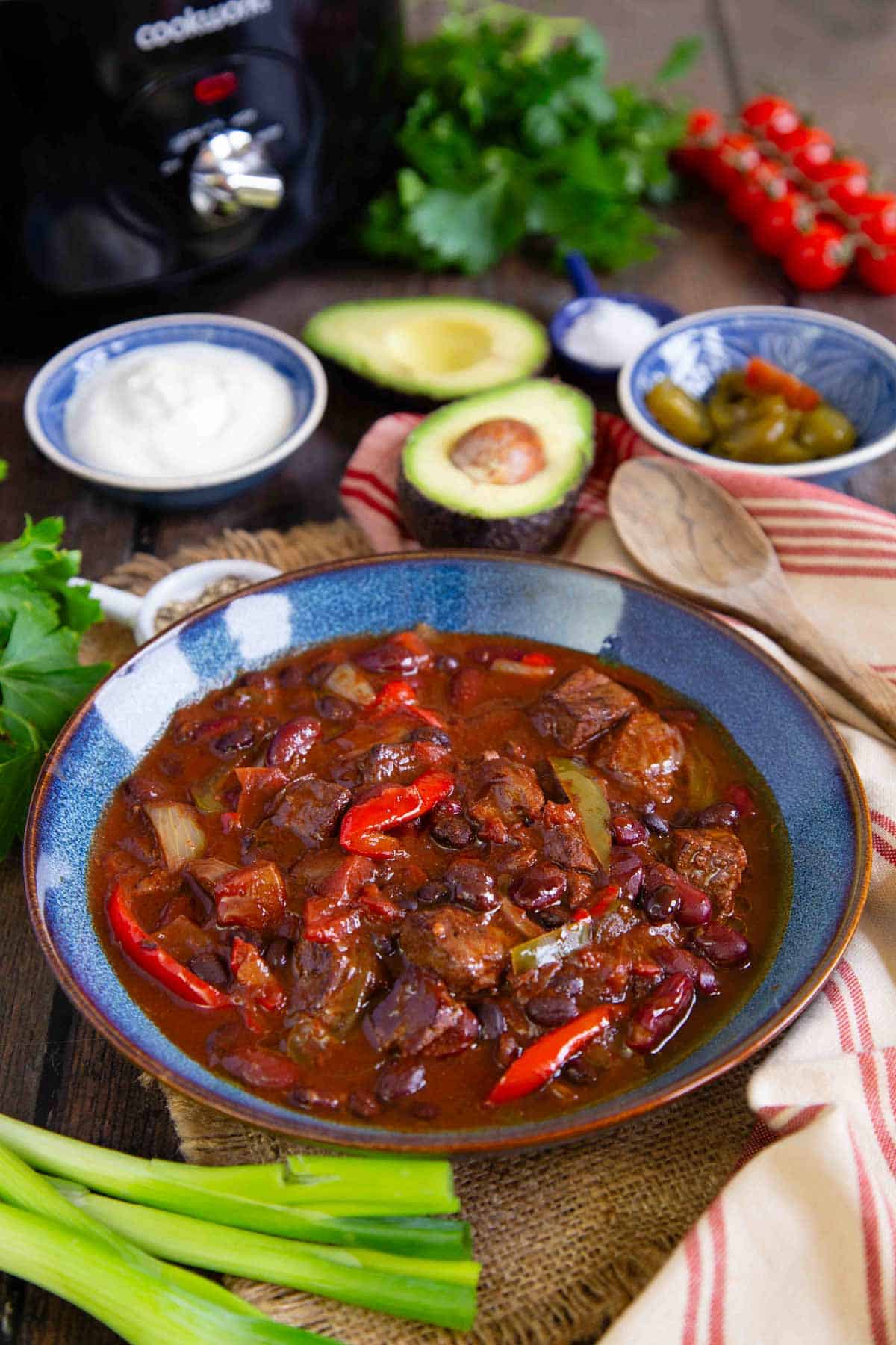 a bowl of freshly cooked chilli con carne surrounded by the traditional chilli toppings