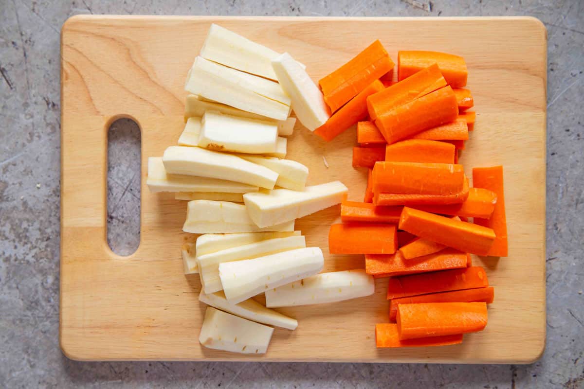 prepared batons of carrots and parsnips on a chopping board
