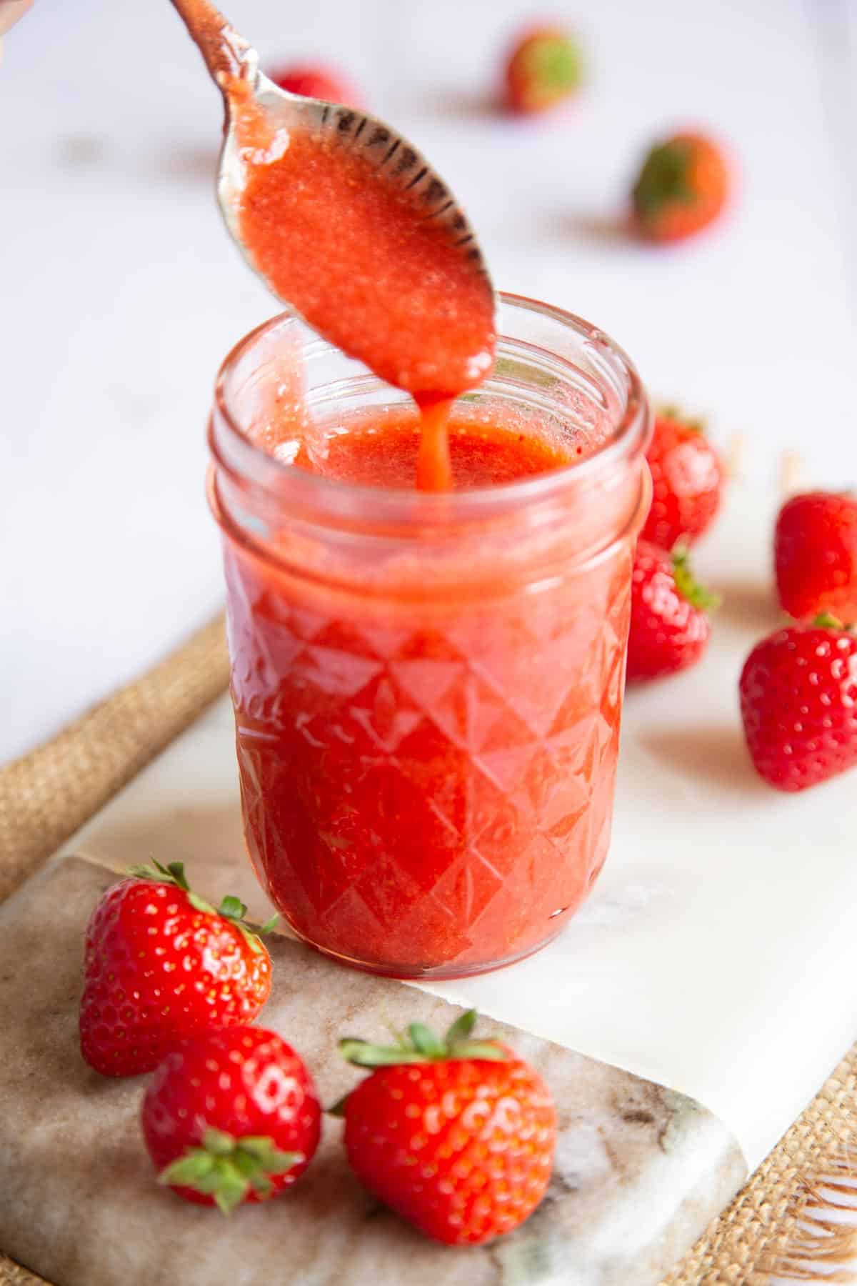 A glass jar of freshly made strawberry coulis