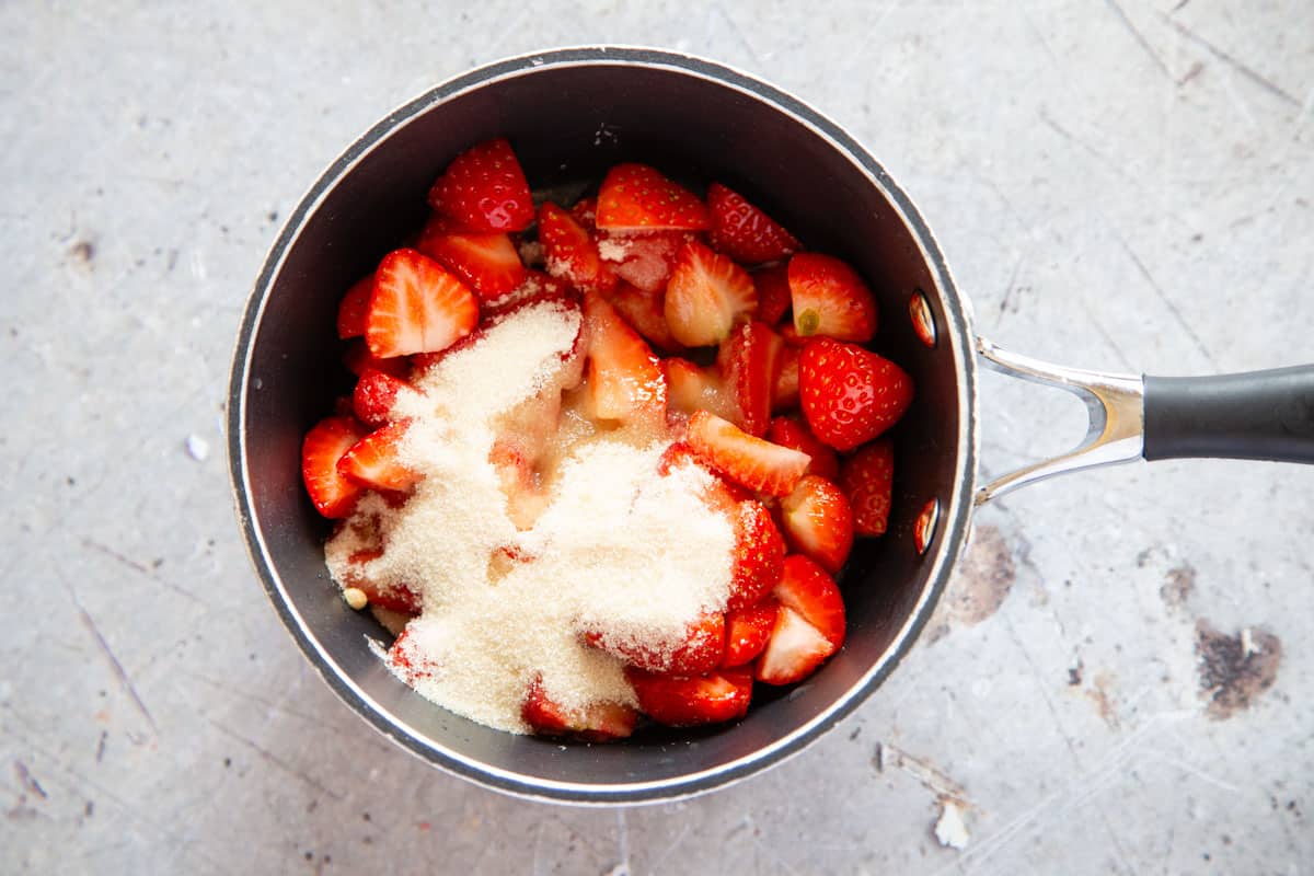 prepared strawberries in a saucepan with sugar