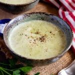 A bowl of creamy broccoli soup on the table ready to enjoy
