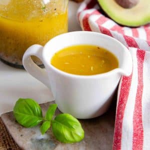 a jug of Mediterranean dressing with salad ingredients