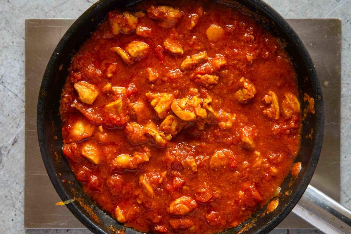 the final curry pieces of chicken in a rich thick tomato sauce