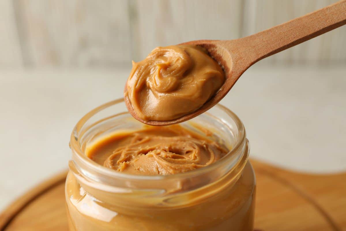 a spoon of nut butter being taken from a jar