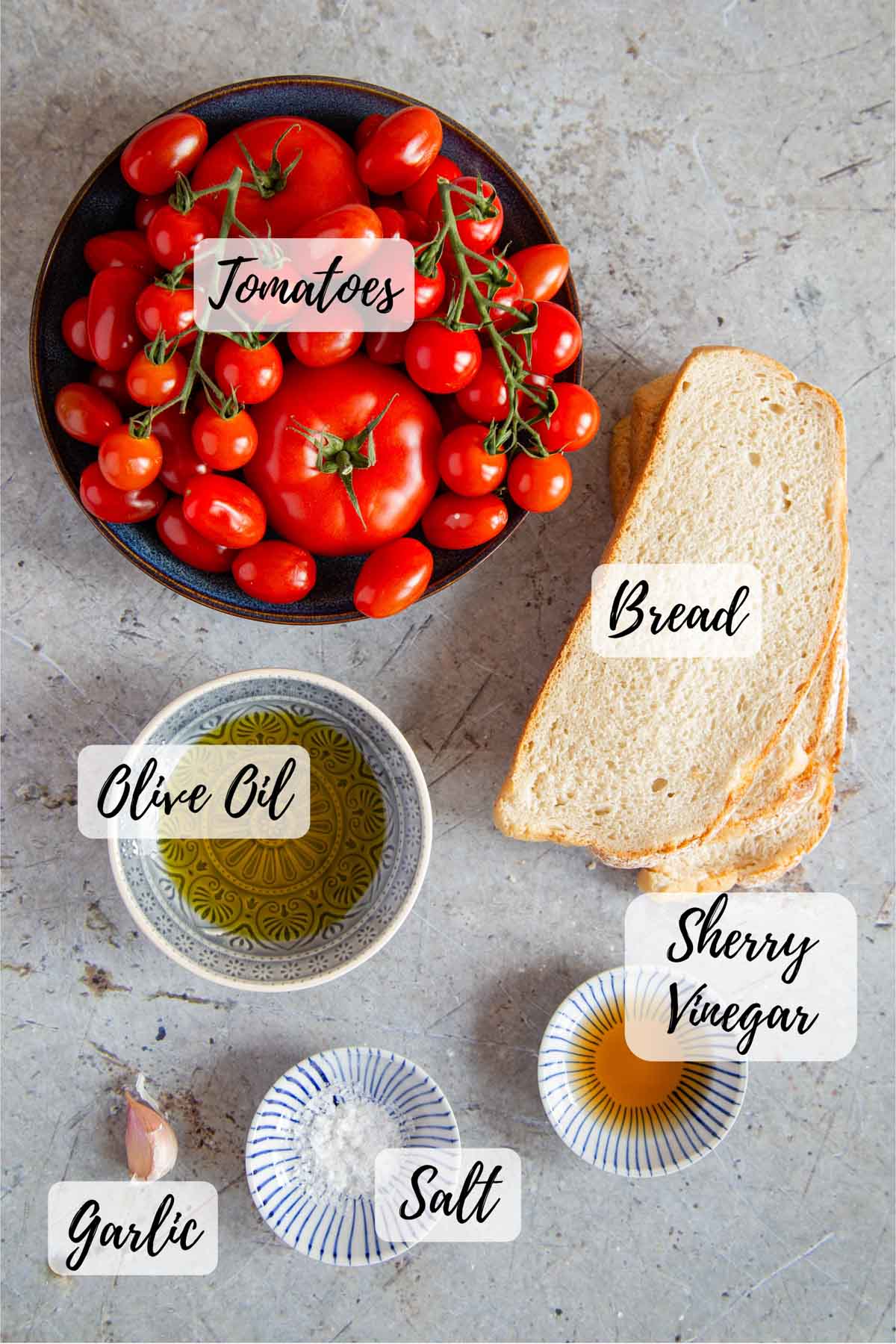 ingredients to make salmorejo laid out on a table. Text overlay labels each one