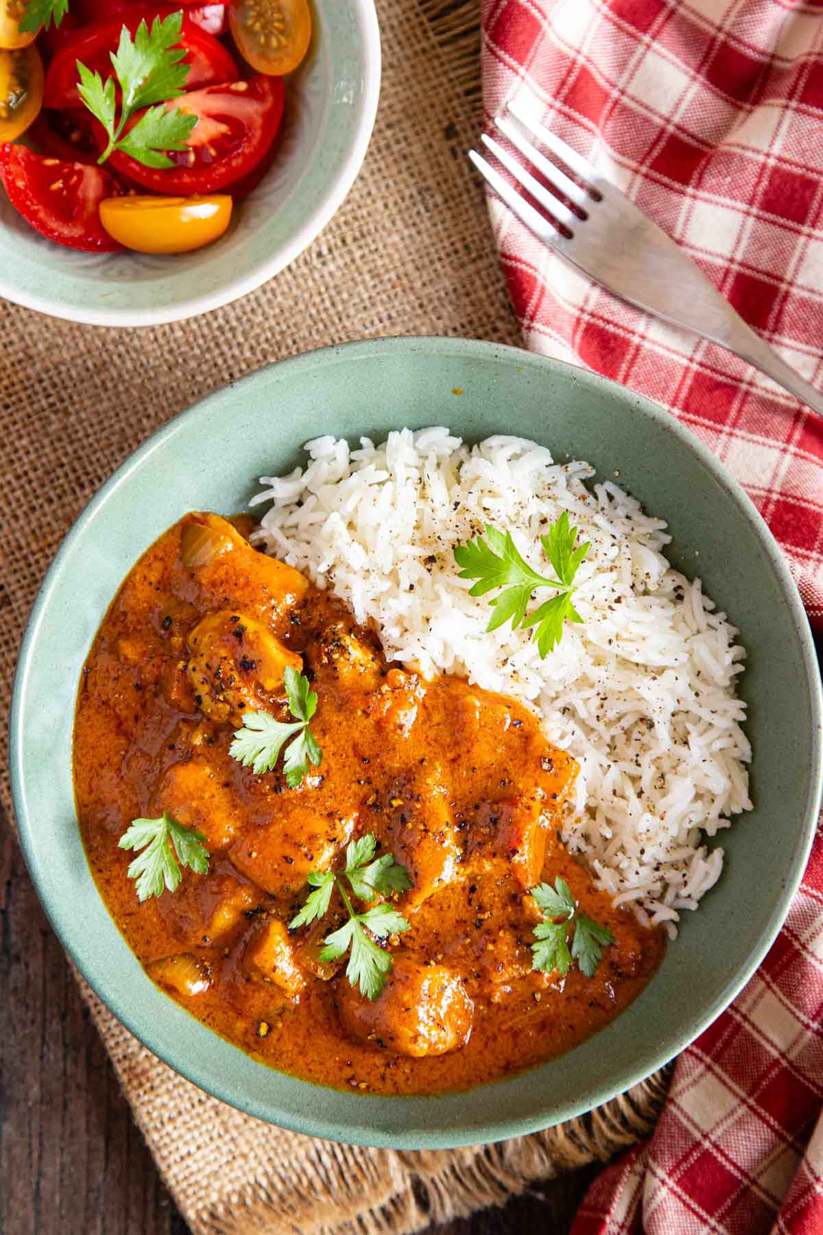 a bowl of quick chicken curry served with steamed rice and a tomato salad