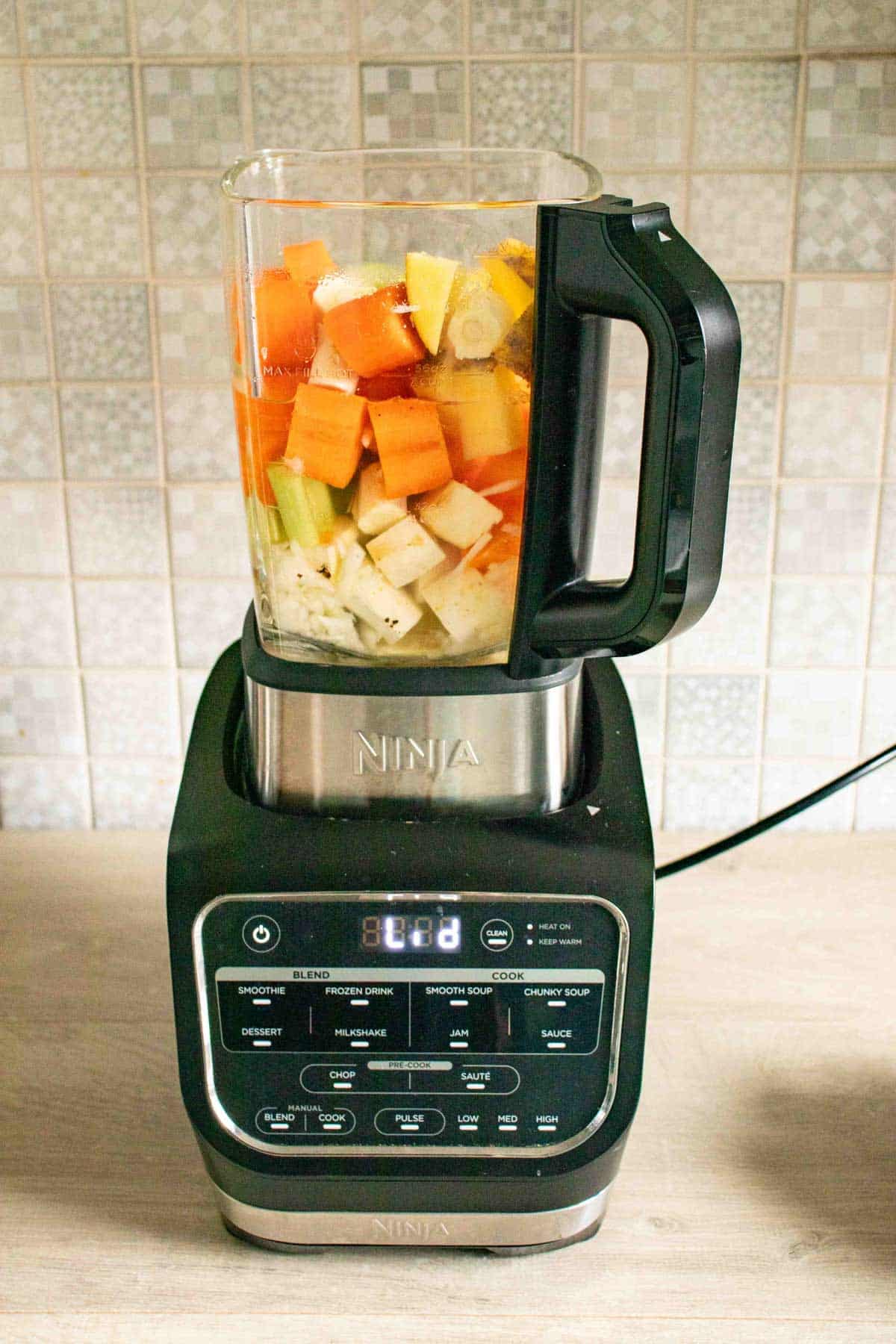 the soup maker is loaded, with the waterline below the level of the vegetables