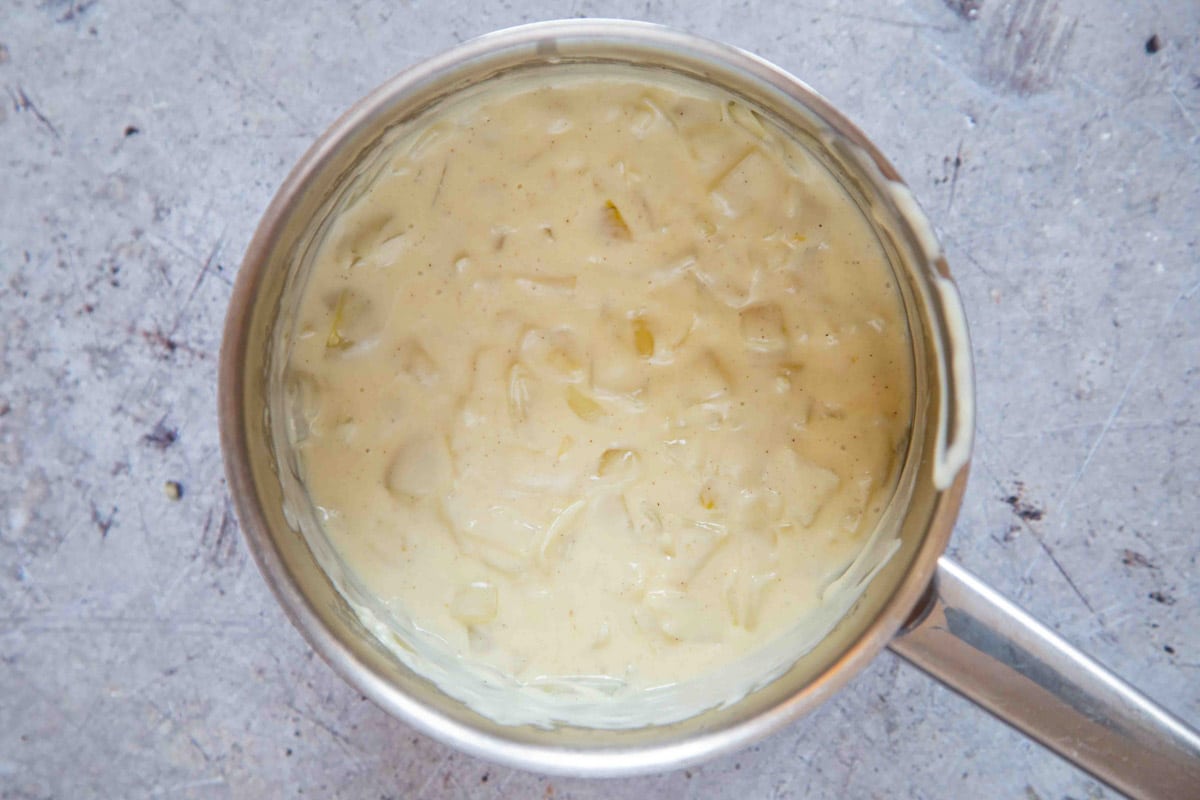 Creamy white onion sauce in a saucepan ready to serve