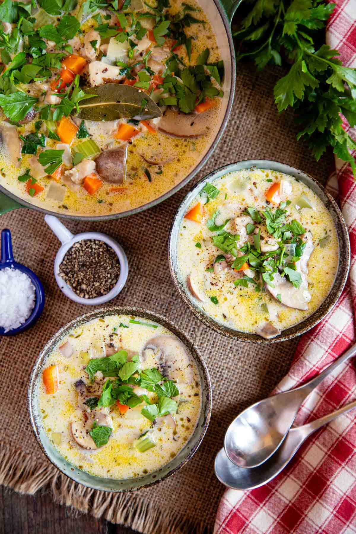 Bowls of chicken and mushroom soup garnished with parsley and ready to serve