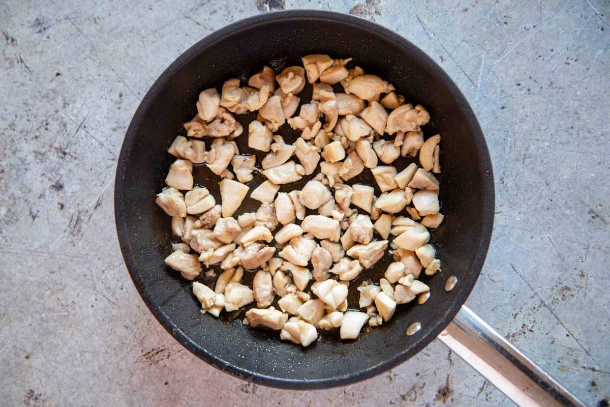 Small pieces of chicken being cooked in a frying pan