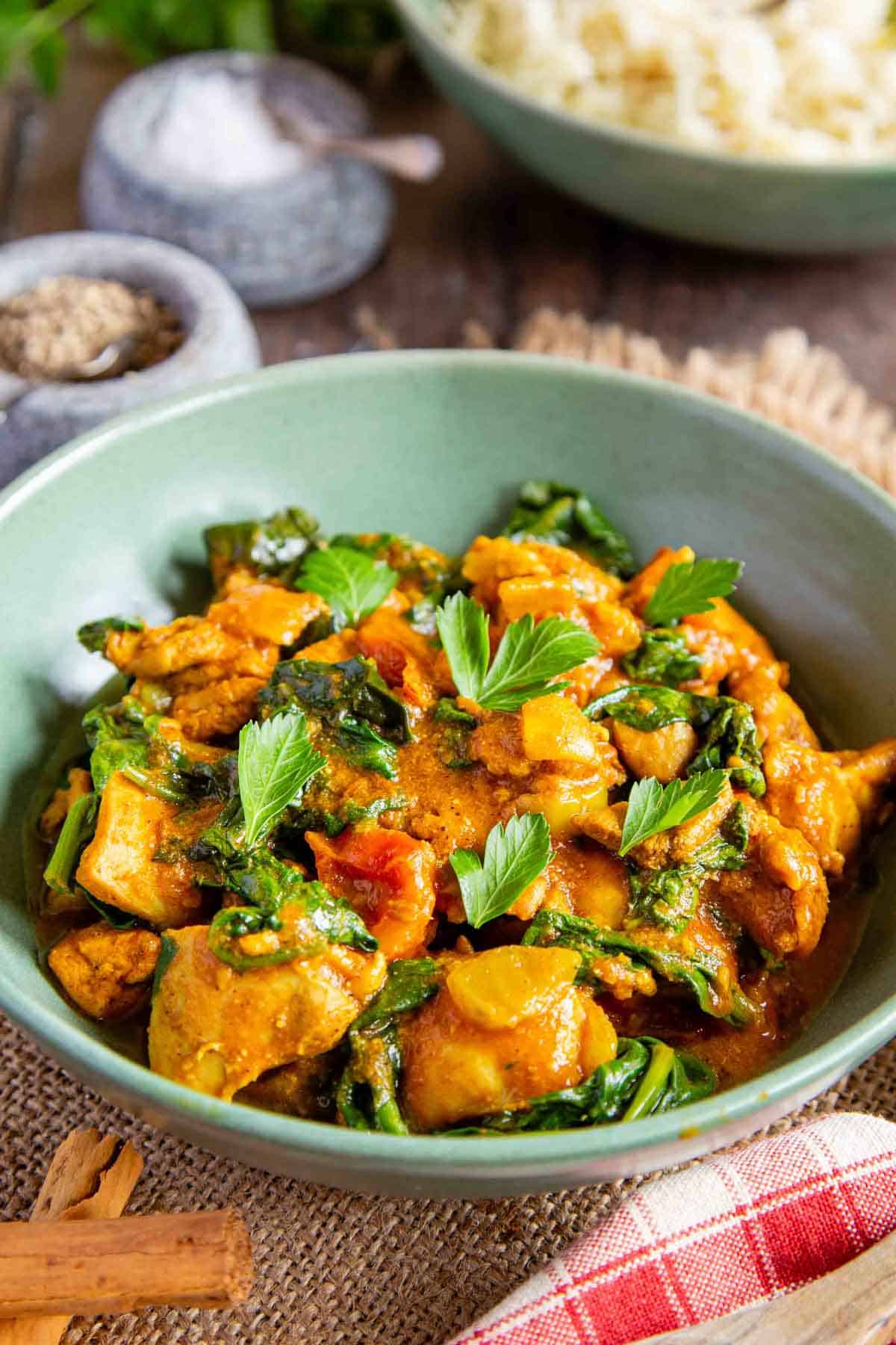 Chicken saag curry with cooked spinach garnished with parsley leaves