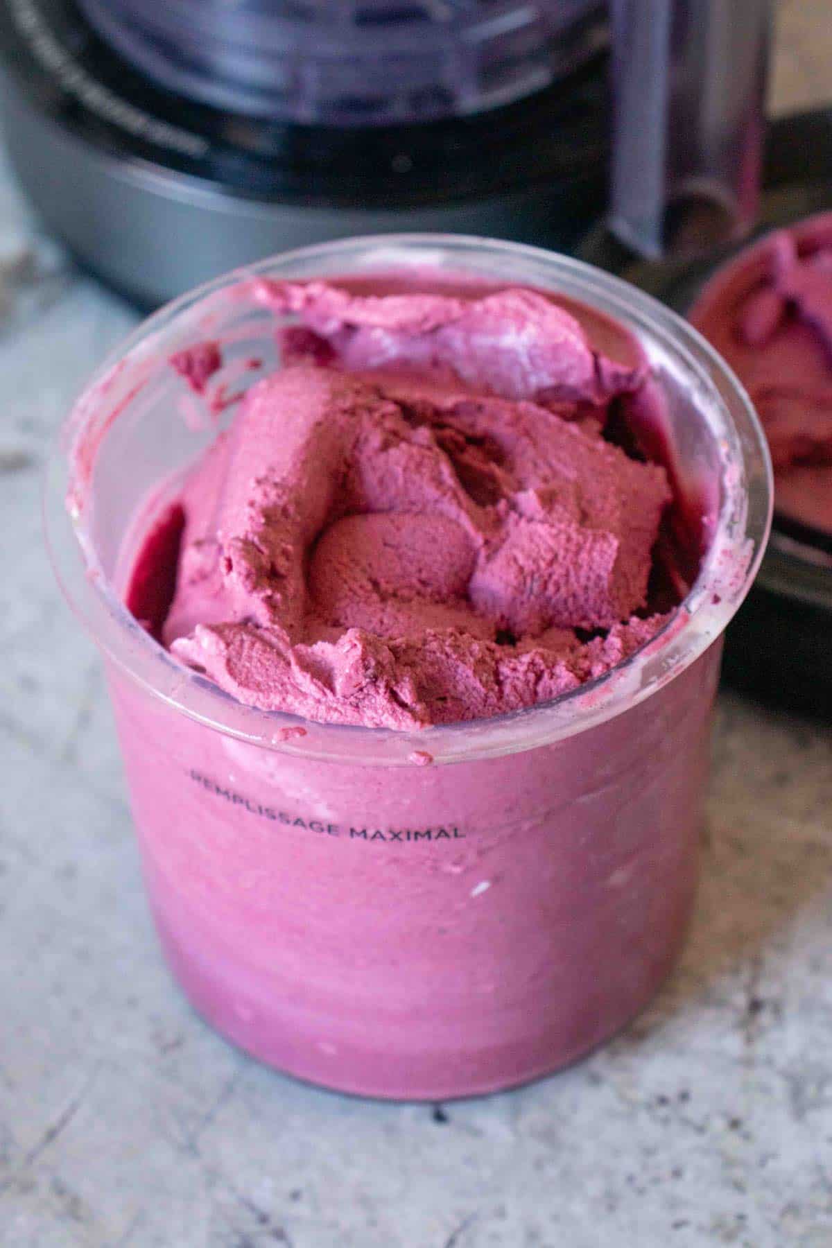Ninja Creami pot full of dark pink frozen yoghurt that has been stirred
