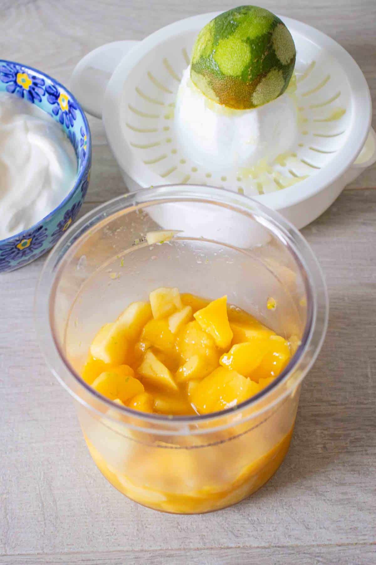 Defrosted and roughly chopped mango with yoghurt and a juiced lime