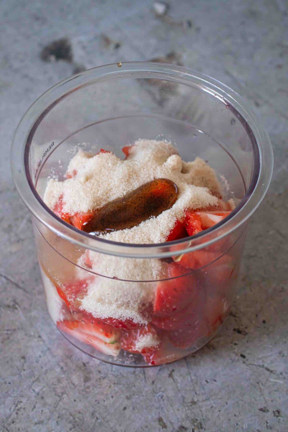 Strawberries sugar and maple syrup in the pot ready to be mixed together