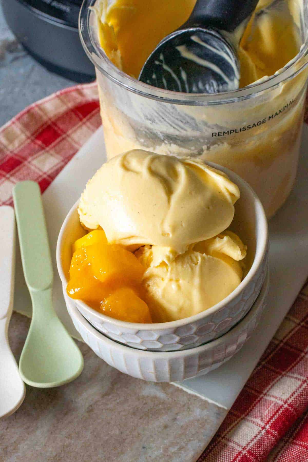 Pale yellow mango ice cream served with extra mango chunks