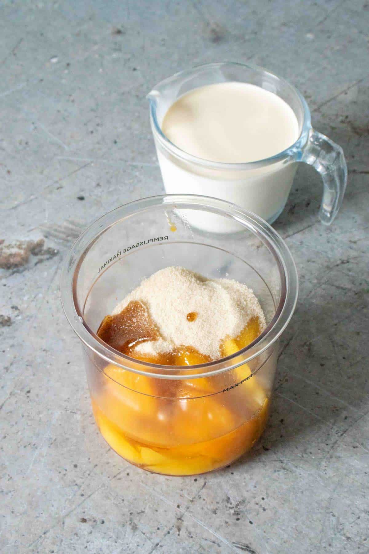 Mango sugar honey and vanilla in the Ninja pot with a jug of cream in the background