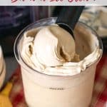 A scoop of banana ice cream being taken from the full pot