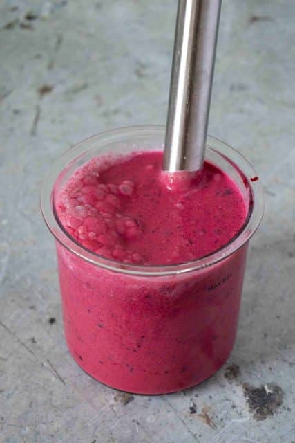 Blending the ice cream mixture in the Ninja Creami pot with a stick blender