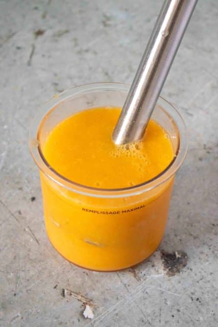 Blending together the mango sorbet ingredients with a stick blender in the Ninja pot
