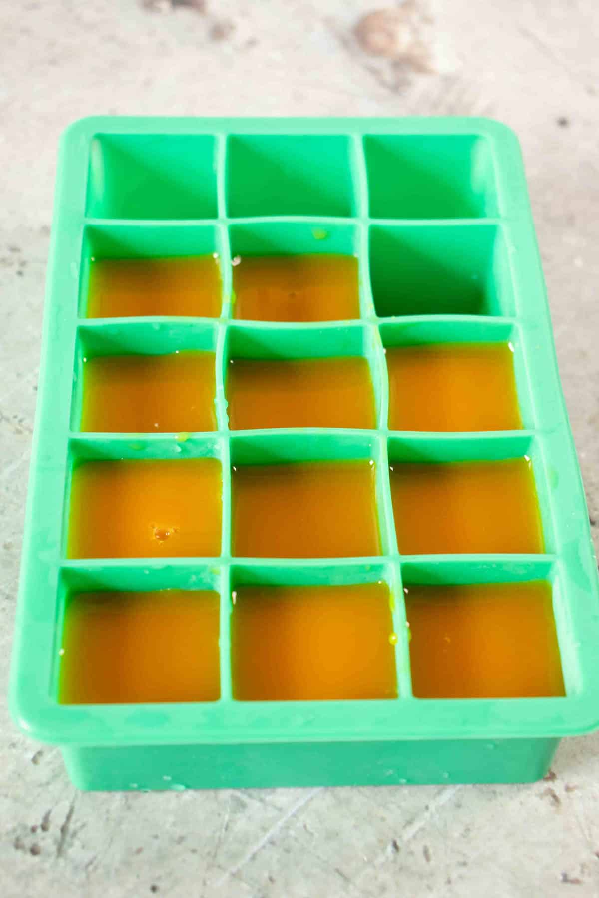 Leftover passionfruit puree in an ice cube tray ready for freezing