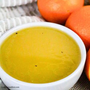 a close up of a white bowl of golden orange dressing