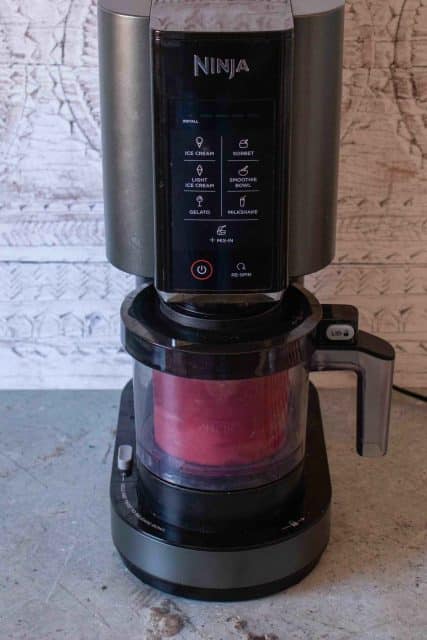 The sorbet in its pot is in the Ninja Creami machine and is being processed