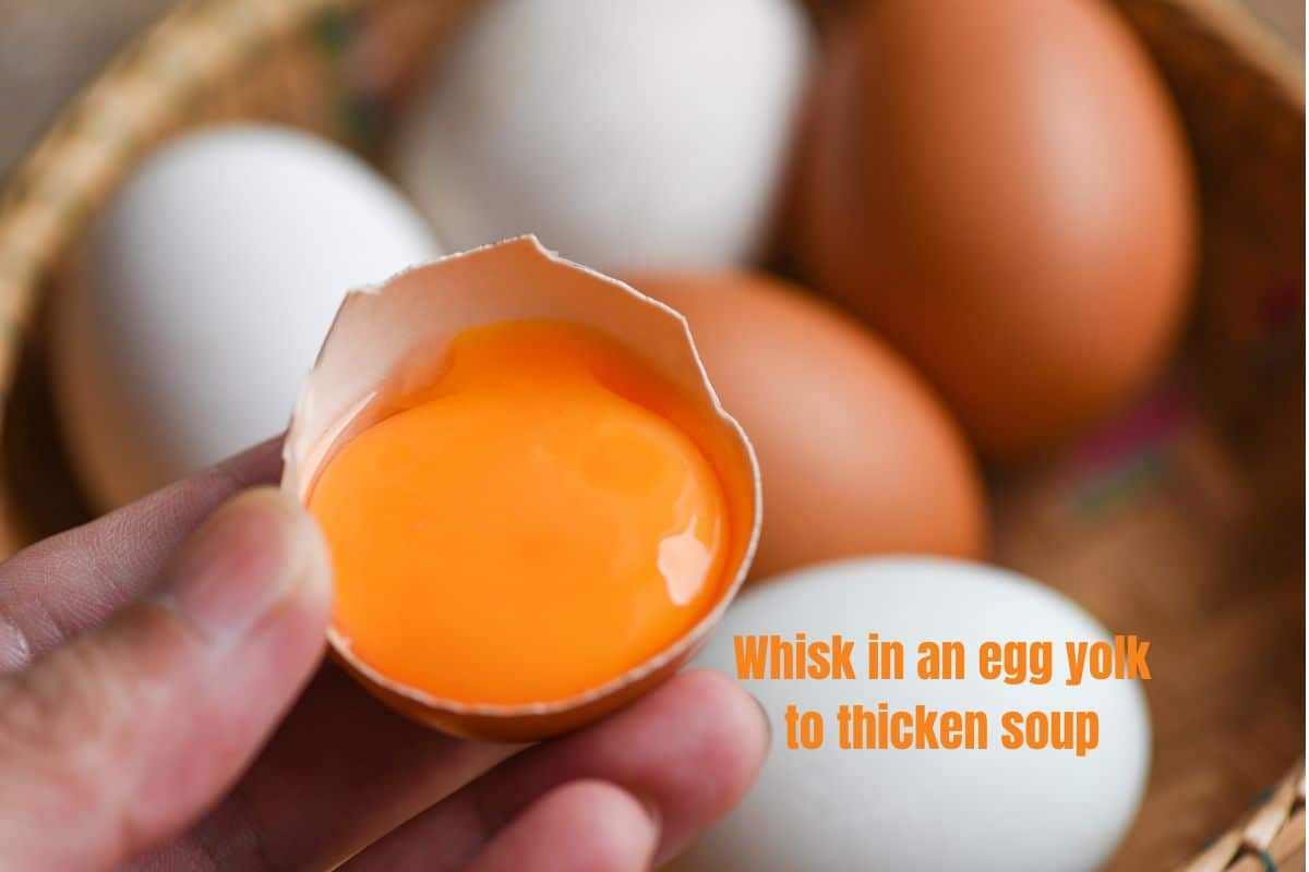 a basket of eggs, with a half shell containing a yolk