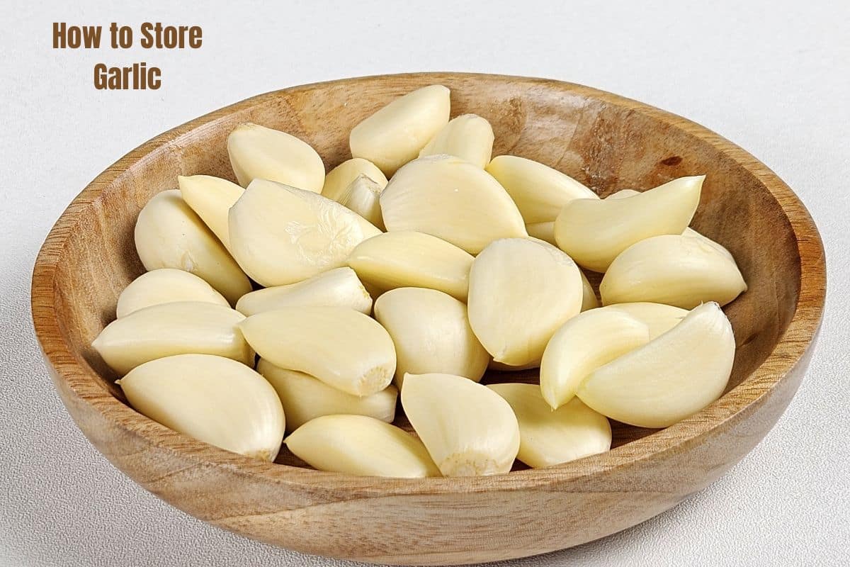 a wooden bowl filled with garlic cloves