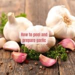cloves and bulbs of garlic garnished with parsley on a wooden board