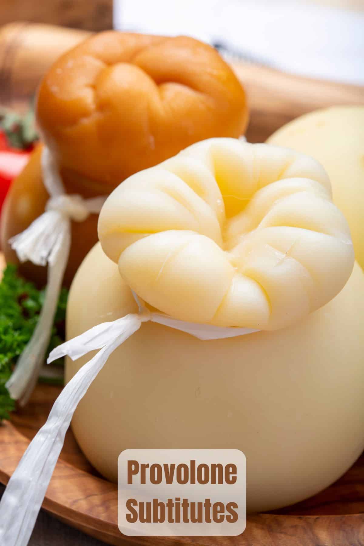 two whole provolone cheeses on a wooden board