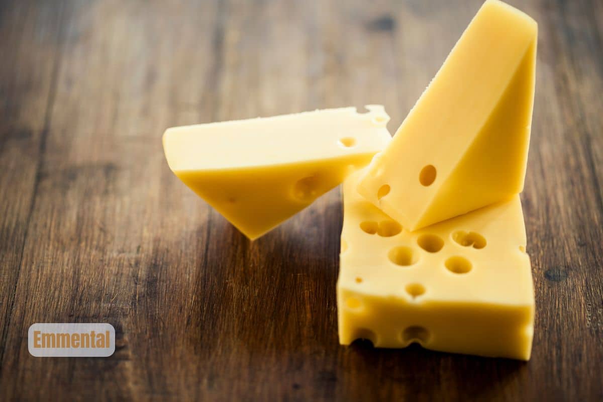 a block and two wedges of Emmental on a wooden board